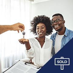 Two people receiving keys to their new home.