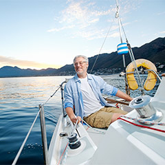 A smiling person sailing on a boat.