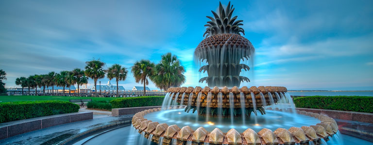 A pineapple-shaped fountain with the South Carolina shoreline in the background.
