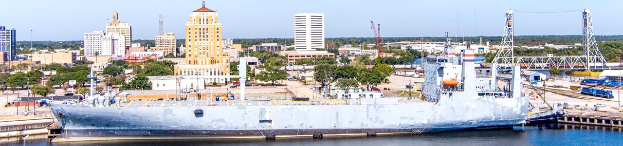 A view of a ship in the commercial dock in Beaumont, Texas, with the city in the background.